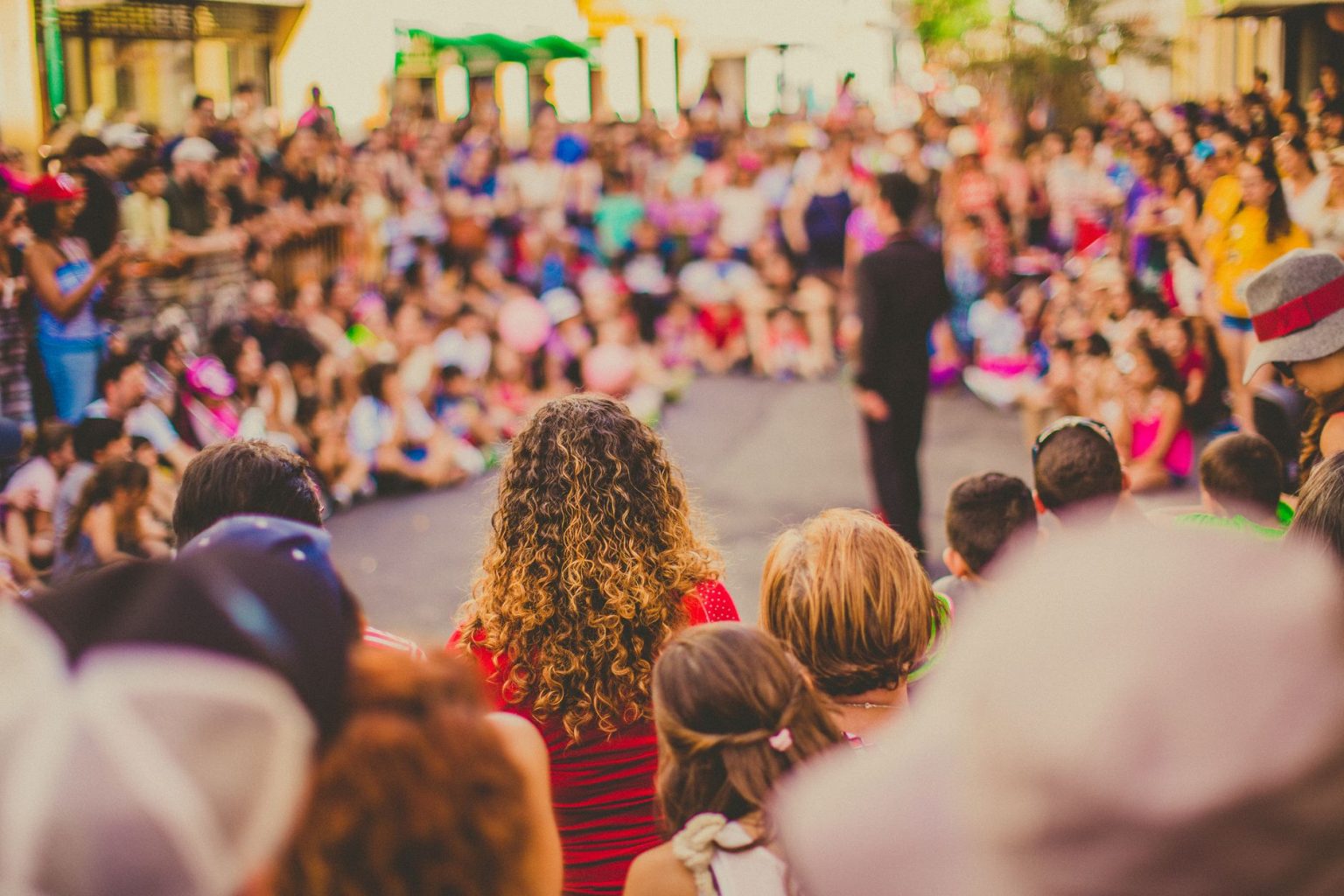 Artistas se apresentam em um espaço público enquanto um público diversificado acompanha a performance.
