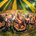 Dançarinos com trajes coloridos se apresentam em um festival cultural brasileiro.