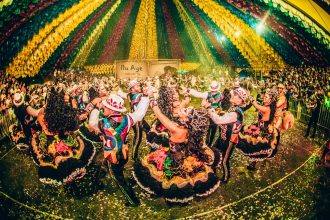 Dançarinos com trajes coloridos se apresentam em um festival cultural brasileiro.